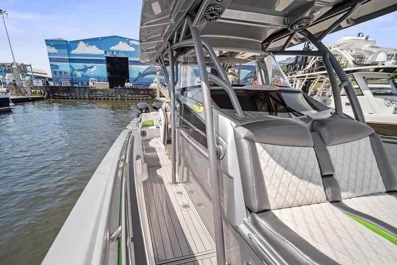 Slide: The Image of 2021 Nor-Tech 390 Sport Center Console boat docked, showcasing sleek design and spacious seating. - 28