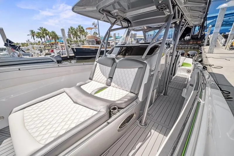 Slide: The Image of 2021 Nor-Tech 390 Sport Center Console boat with sleek seating and modern design at a marina. - 29
