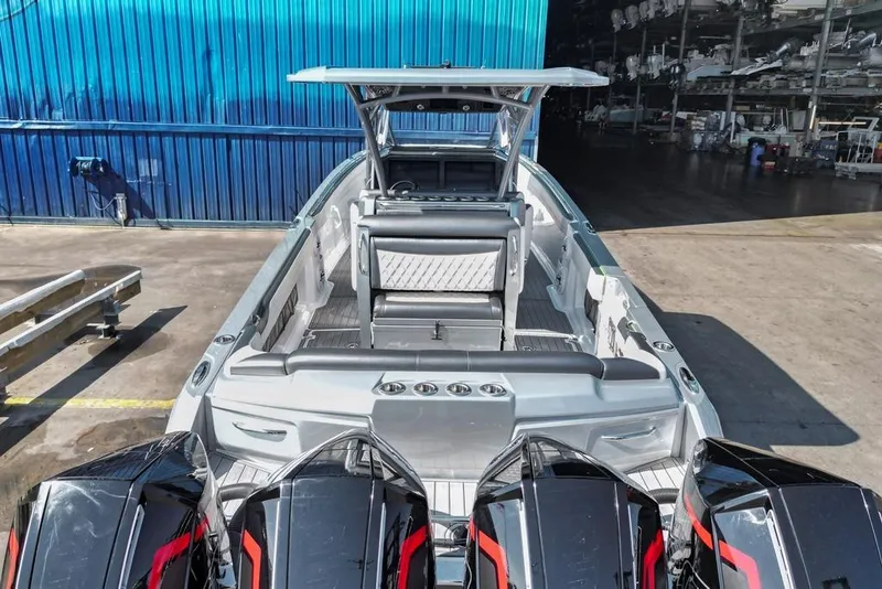 Slide: The Image of 2021 Nor-Tech 390 Sport Center Console boat with multiple outboard engines in a marina. - 45