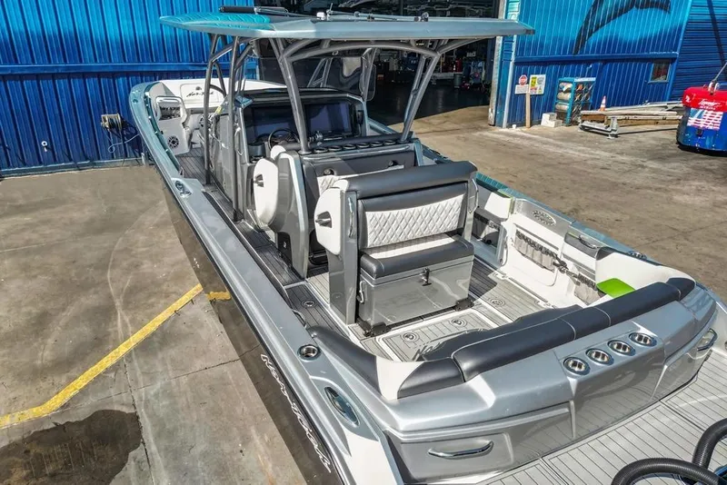 Slide: The Image of 2021 Nor-Tech 390 Sport Center Console boat in a marina, showcasing sleek design and seating. - 48