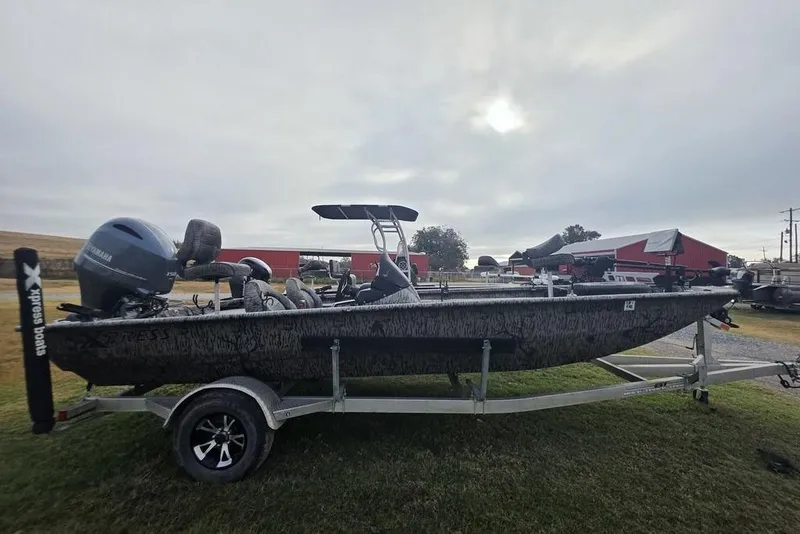 Slide: The Image of 2022 Xpress XP200 Catfish boat on trailer, parked outdoors near red barns. - 8
