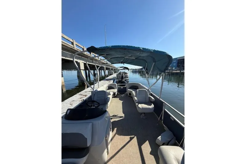 Slide: The Image of 2024 Island Breeze 232 pontoon boat docked under clear blue sky. - 10
