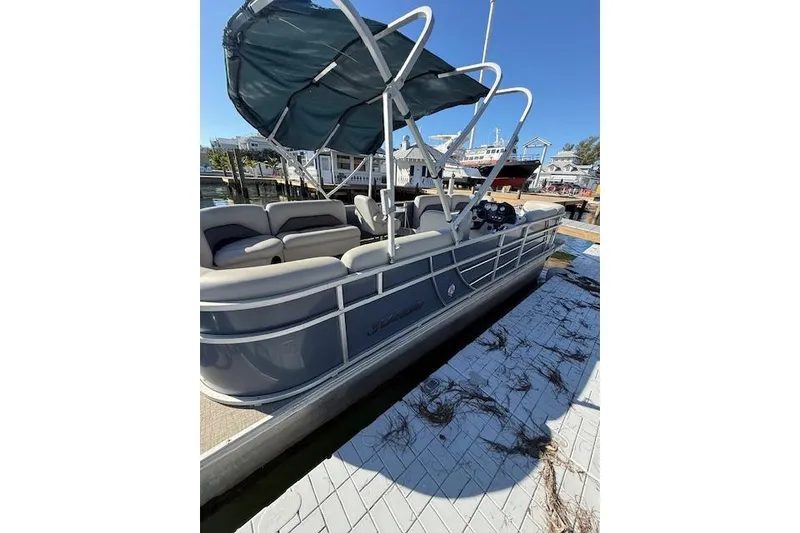 Slide: The Image of 2024 Island Breeze 232 pontoon boat docked with canopy and seating. - 6