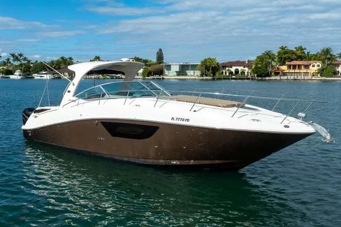 The Image of 2010 Sea Ray 370 Sundancer yacht on calm water, surrounded by waterfront homes. - 0