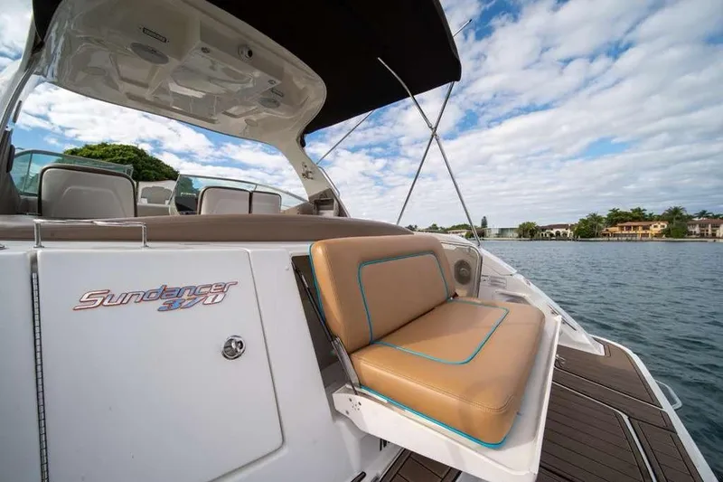 Slide: The Image of 2010 Sea Ray 370 Sundancer boat with tan seating, docked on a sunny day. - 13