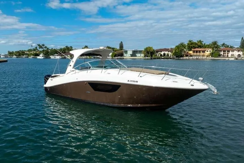 Slide: The Image of 2010 Sea Ray 370 Sundancer yacht on calm water, with scenic waterfront background. - 17