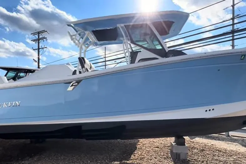 The Image of 2024 Blackfin 302CC boat in light blue, displayed outdoors under a sunny sky. - 1
