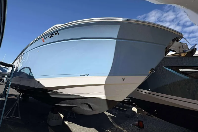 Slide: The Image of 2024 Blackfin 302CC boat in light blue, docked under clear sky. - 3