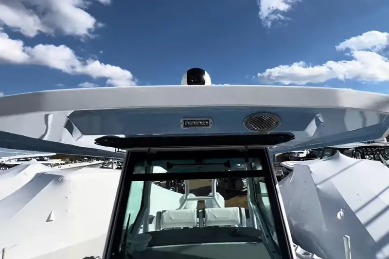 Slide: The Image of 2024 Blackfin 302CC boat with sleek design under a clear blue sky. - 7