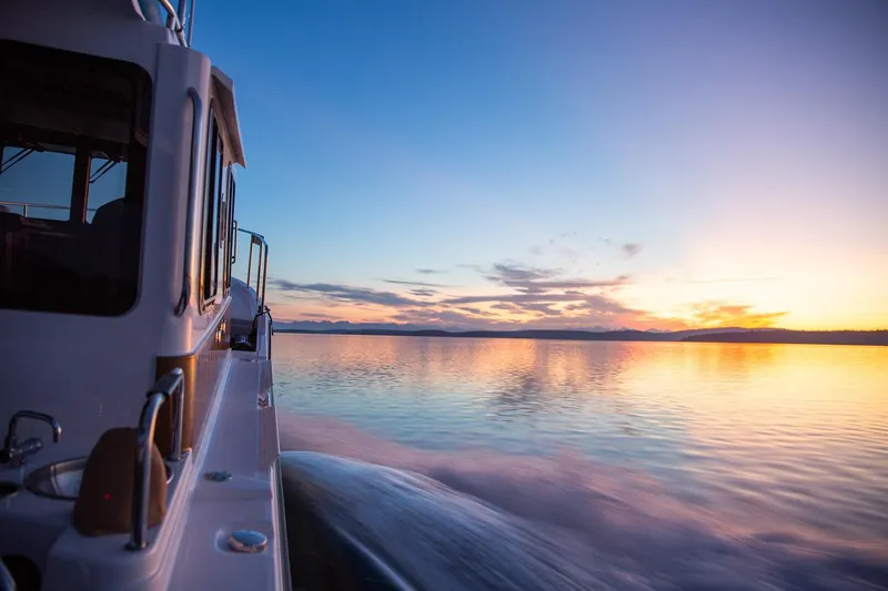 Slide: The Image of 2026 Ranger Tugs R-31S cruising at sunset on calm waters. - 15