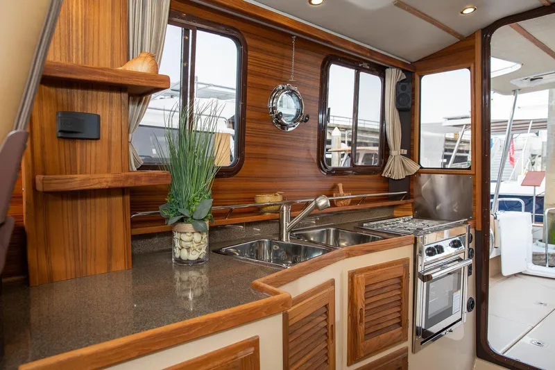 Slide: The Image of Luxurious 2026 Ranger Tugs R-31S yacht interior with elegant wood finishes and modern kitchen amenities. - 18
