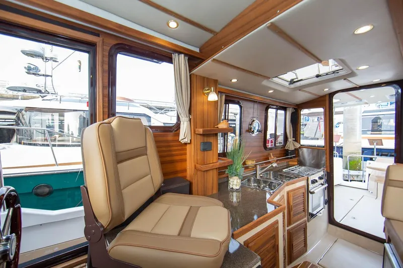 Slide: The Image of Interior of 2026 Ranger Tugs R-31S, featuring elegant wood finishes and modern amenities. - 21