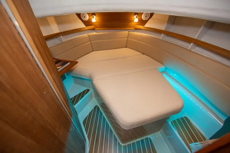 Slide: The Image of 2026 Ranger Tugs R-31S interior cabin with cozy seating and ambient lighting. - 22