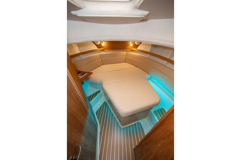 Slide: The Image of 2026 Ranger Tugs R-31S interior cabin with cozy seating and ambient lighting. - 23