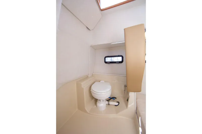 Slide: The Image of 2026 Ranger Tugs R-31S boat bathroom interior with compact toilet and window. - 30