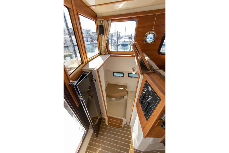 Slide: The Image of 2026 Ranger Tugs R-31S interior with wood accents and compact bathroom. - 31