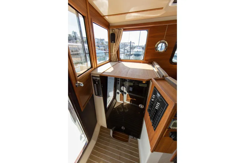 Slide: The Image of 2026 Ranger Tugs R-31S interior with wood paneling and control panels. - 32