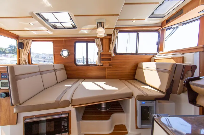 Slide: The Image of Interior of 2026 Ranger Tugs R-31S, featuring cozy seating and elegant wood finishes. - 35