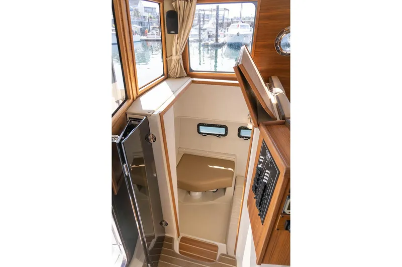 Slide: The Image of 2026 Ranger Tugs R-31S interior cabin with wood accents and compact design. - 36