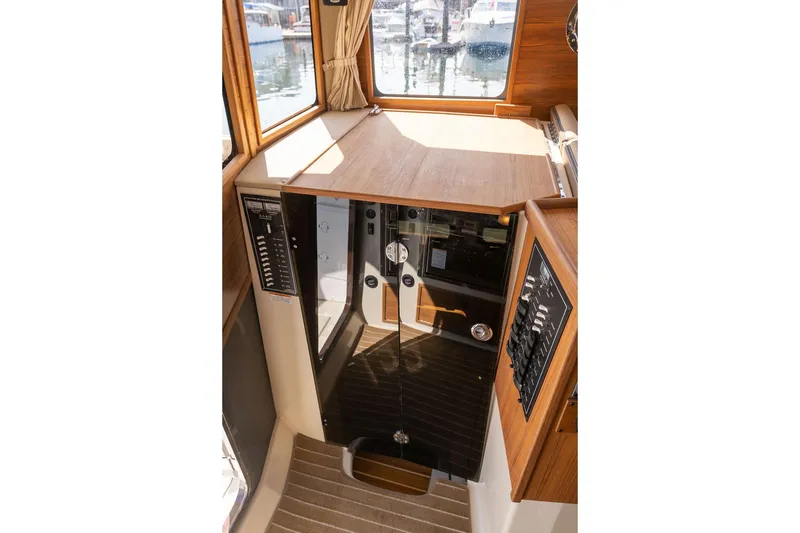Slide: The Image of 2026 Ranger Tugs R-31S interior helm station with wood finish and control panels. - 37