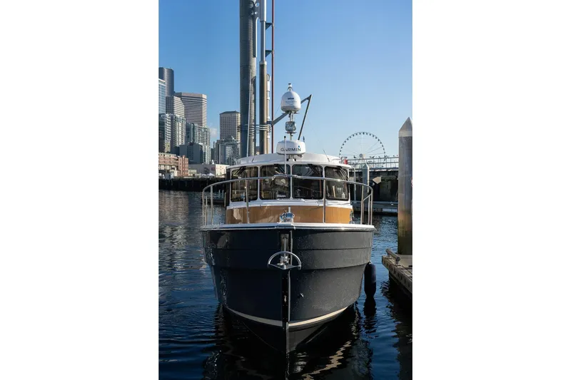 Slide: The Image of 2026 Ranger Tugs R-31S docked in urban marina with city skyline backdrop. - 7