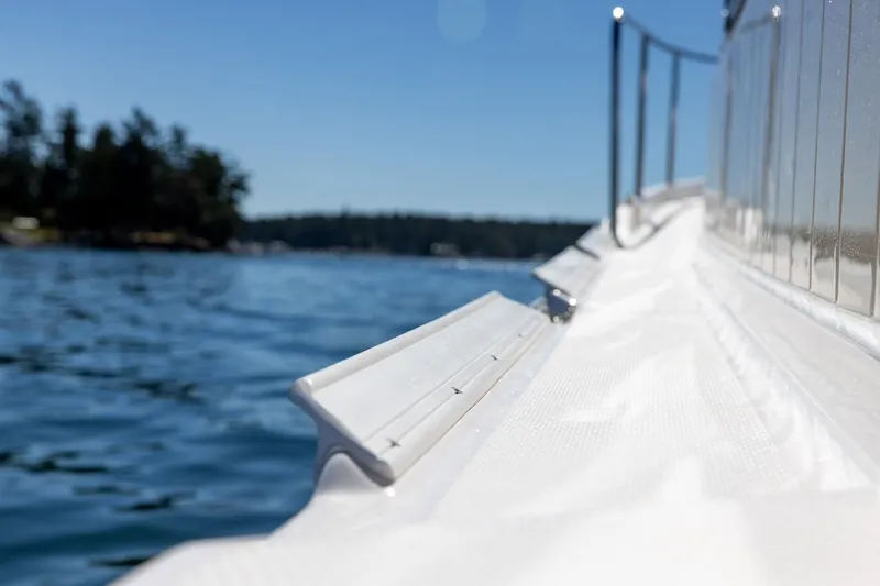 Slide: The Image of Close-up of 2026 Ranger Tugs R-31S boat railing on calm water. - 8