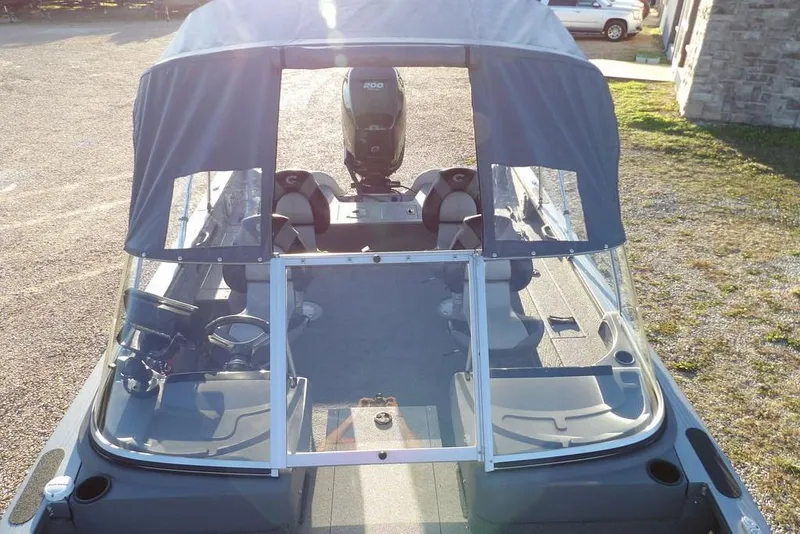 Slide: The Image of 2018 Crestliner 1950 Fish Hawk WT boat with canopy and seating, parked outdoors. - 40