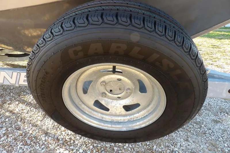 Slide: The Image of Carlisle tire on a 2018 Crestliner 1950 Fish Hawk WT trailer, parked on gravel. - 61