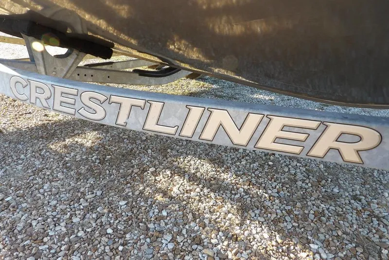 Slide: The Image of Crestliner 1950 Fish Hawk WT 2018 boat trailer on gravel surface. - 63