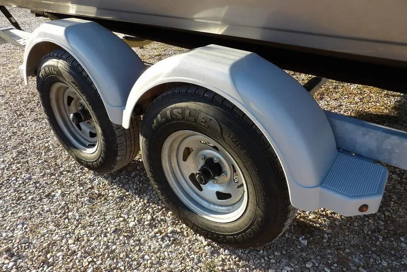 Slide: The Image of 2018 Crestliner 1950 Fish Hawk WT trailer with dual wheels on gravel surface. - 65