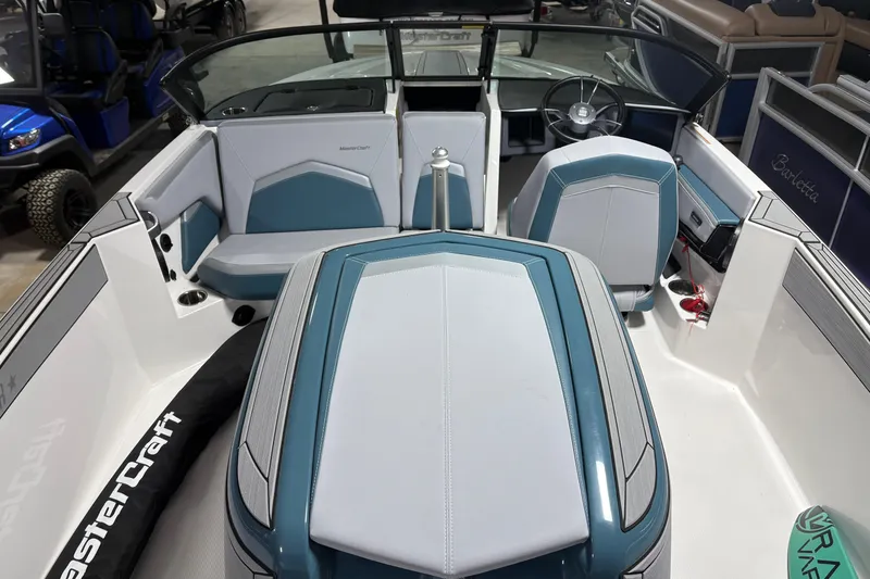Slide: The Image of 2025 MasterCraft ProStar boat interior with blue and white seating and steering wheel. - 8