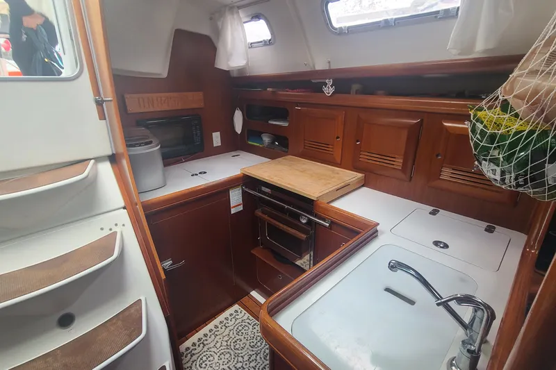 Slide: The Image of Interior of 2005 Beneteau Oceanis 393 sailboat with cozy seating and wooden finishes. - 10