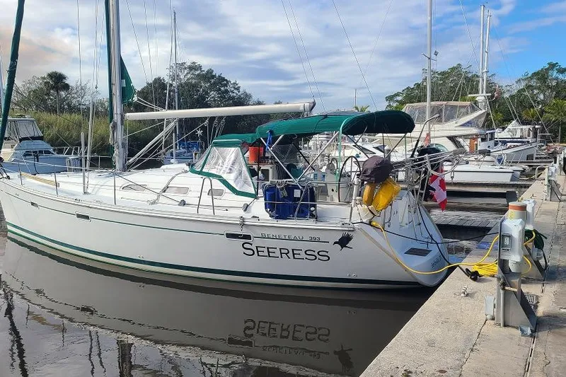 Slide: The Image of Sailboat Beneteau Oceanis 393, 2005 model, docked in a serene marina setting. - 2
