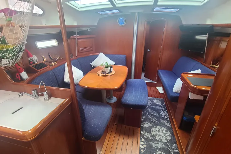 Slide: The Image of Interior of 2005 Beneteau Oceanis 393 sailboat, featuring cozy cabin and wooden flooring. - 9