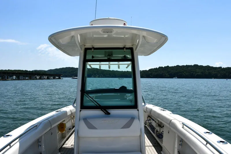 Slide: The Image of 2016 Boston Whaler 280 Outrage boat on a serene lake with distant shoreline. - 11