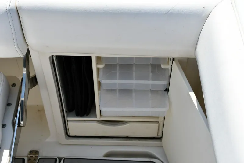 Slide: The Image of Storage compartment on a 2016 Boston Whaler 280 Outrage boat, featuring organized tackle boxes. - 27
