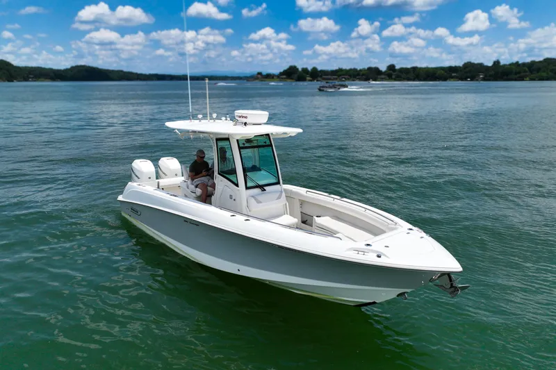 Slide: The Image of 2016 Boston Whaler 280 Outrage boat on calm water under a blue sky. - 7