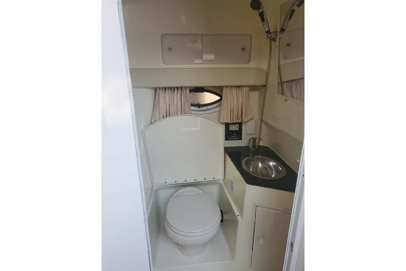 Slide: The Image of 2015 Monterey 315 Sport Yacht bathroom with toilet, sink, and showerhead. - 21