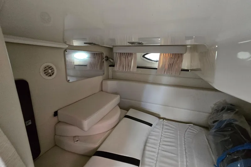 Slide: The Image of Interior cabin of 2015 Monterey 315 Sport Yacht with cushioned seating and porthole window. - 28