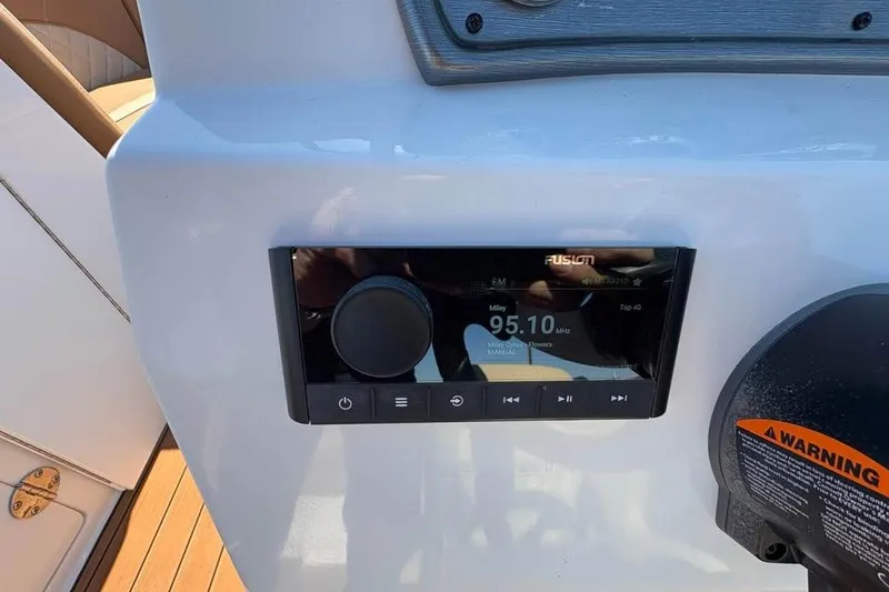 Slide: The Image of 2026 NauticStar 223 DC Deck boat dashboard with Fusion stereo system. - 14