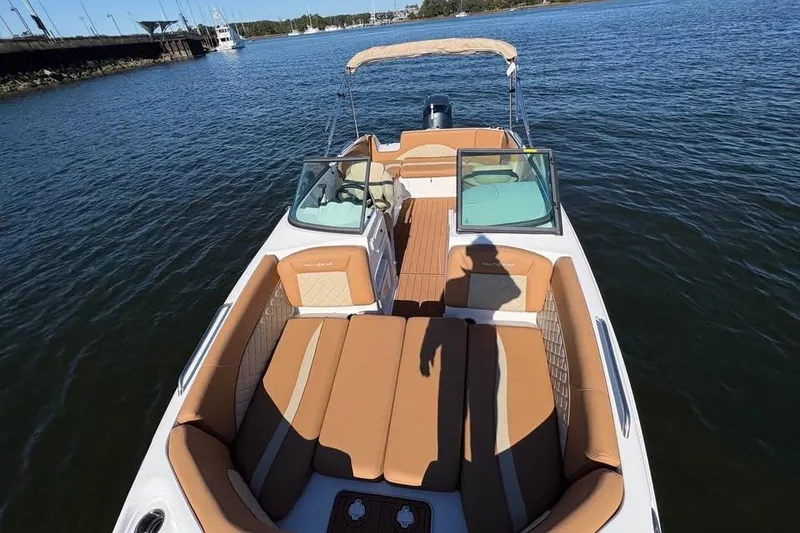 Slide: The Image of 2026 NauticStar 223 DC Deck boat on water, featuring spacious seating and elegant design. - 15