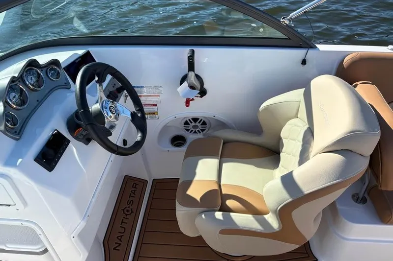 Slide: The Image of 2026 NauticStar 223 DC Deck boat interior with steering wheel and comfortable seating. - 7