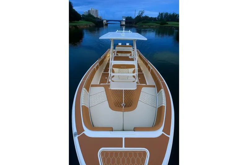 Slide: The Image of 2019 Century 3200 Center Console boat on calm water, featuring spacious seating and sleek design. - 23