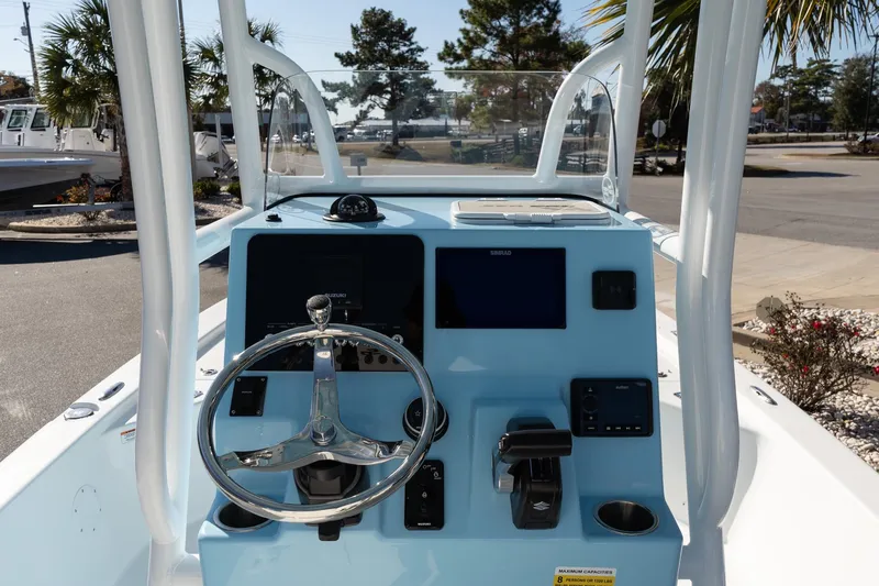 Slide: The Image of 2026 Sea Pro 230 Bay boat dashboard with steering wheel and navigation controls. - 12