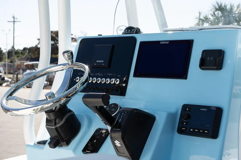 Slide: The Image of 2026 Sea Pro 230 Bay boat dashboard with steering wheel and electronic controls. - 13