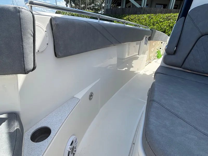 Slide: The Image of 2023 Stingray 273 CC boat interior with cushioned seating and cup holder. - 10