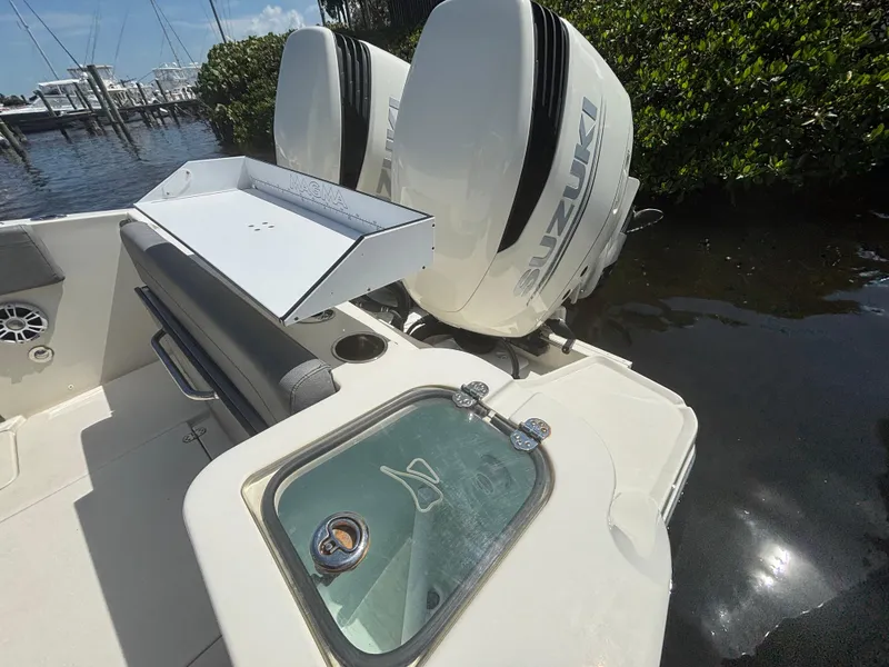 Slide: The Image of 2023 Stingray 273 CC boat with Suzuki engines and fishing station, docked by water. - 22