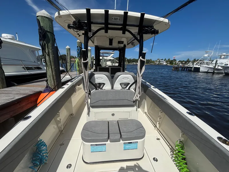 Slide: The Image of 2023 Stingray 273 CC boat interior at dock, featuring seating and open water view. - 23