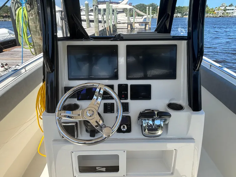 Slide: The Image of 2023 Stingray 273 CC boat dashboard with steering wheel and dual screens. - 25