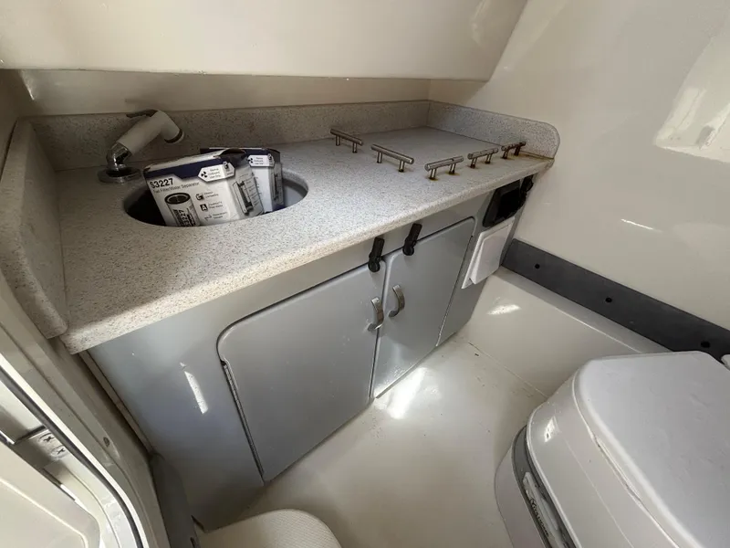 Slide: The Image of 2023 Stingray 273 CC boat interior with sink, countertop, and storage cabinets. - 33